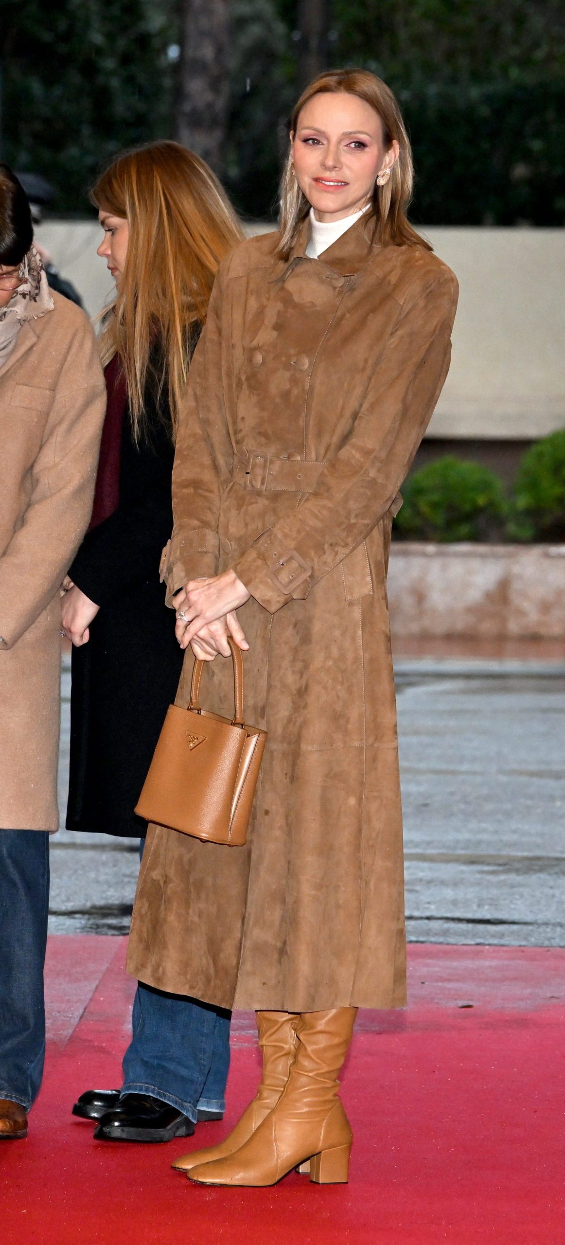 ​Charlène de Mónaco, un look de lujo para una princesa: el bolso Panier de Prada (en su versión pequeña y en color caramelo) con botas altas de Miu Miu 